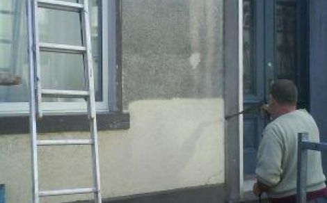 Ein Feuchtigkeitsexperte von Murprotec imprägniert die Fassade