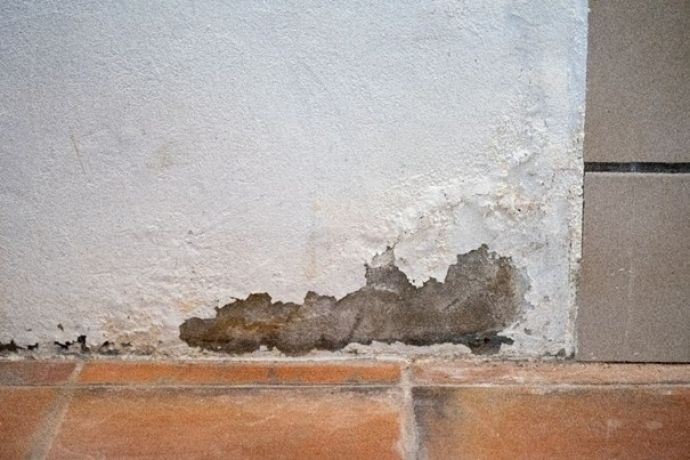 Eine Wand mit abblätternder Farbe unten