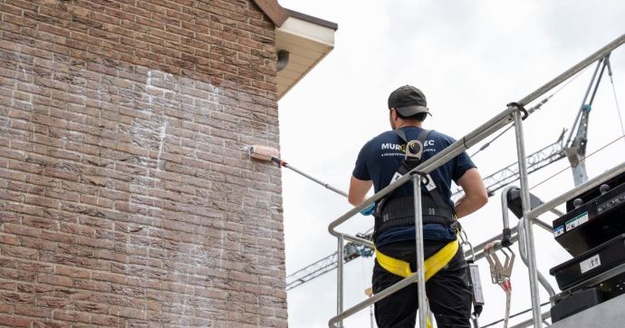 Ein Murprotec-Feuchtigkeitsexperte imprägniert die Fassade mit einem wasserabweisenden Mittel