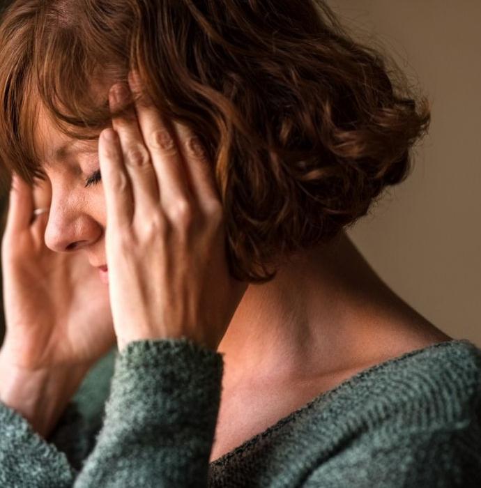 Une femme souffre de maux de tête et se frictionne les tempes