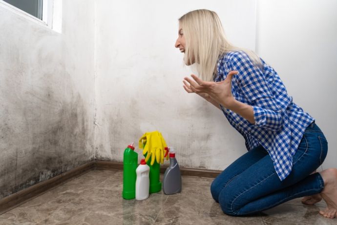 Verzweifelte Frau will  ihre Wand wasserdicht machen. 