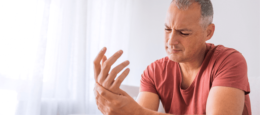 un homme souffre de douleurs aux mains causÃ©es par des rhumatismes